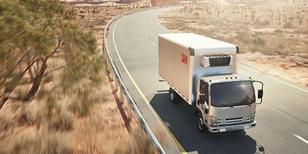 Box truck with 3M cooling film applied to the roof driving down a sunny highway in the desert